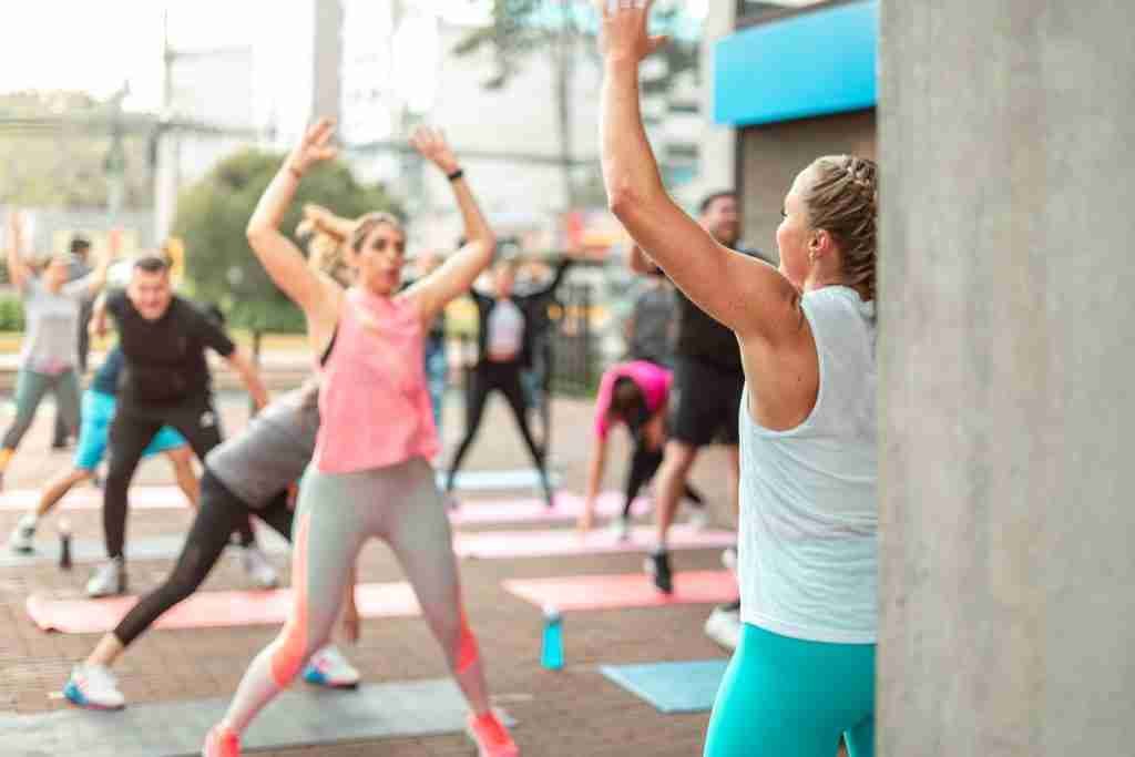 a group of people doing yoga outside on a sunny day