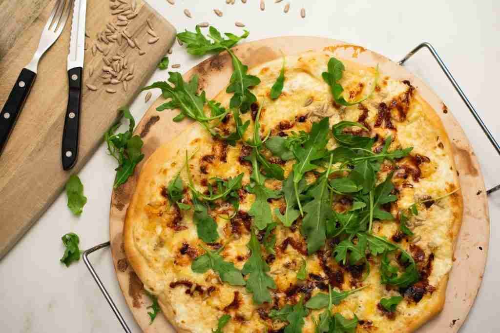 a pizza sitting on top of a wooden cutting board