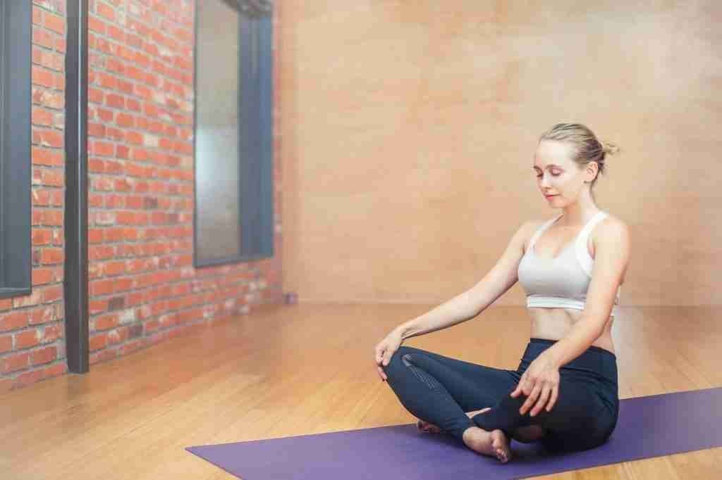 women doing yoga on yoga mat.