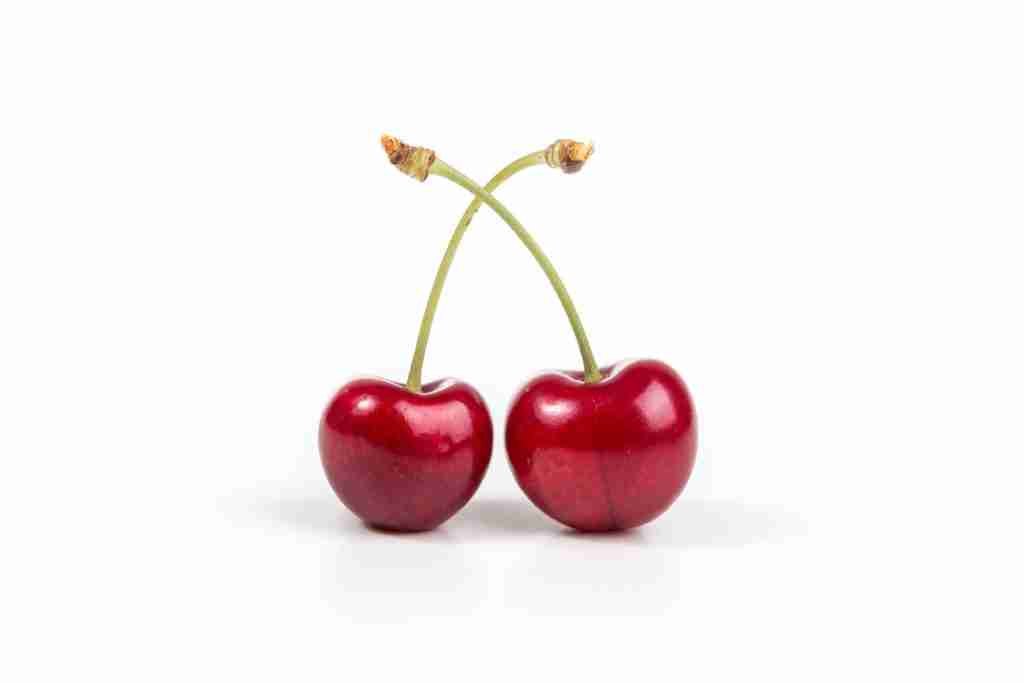 two cherries on white surface