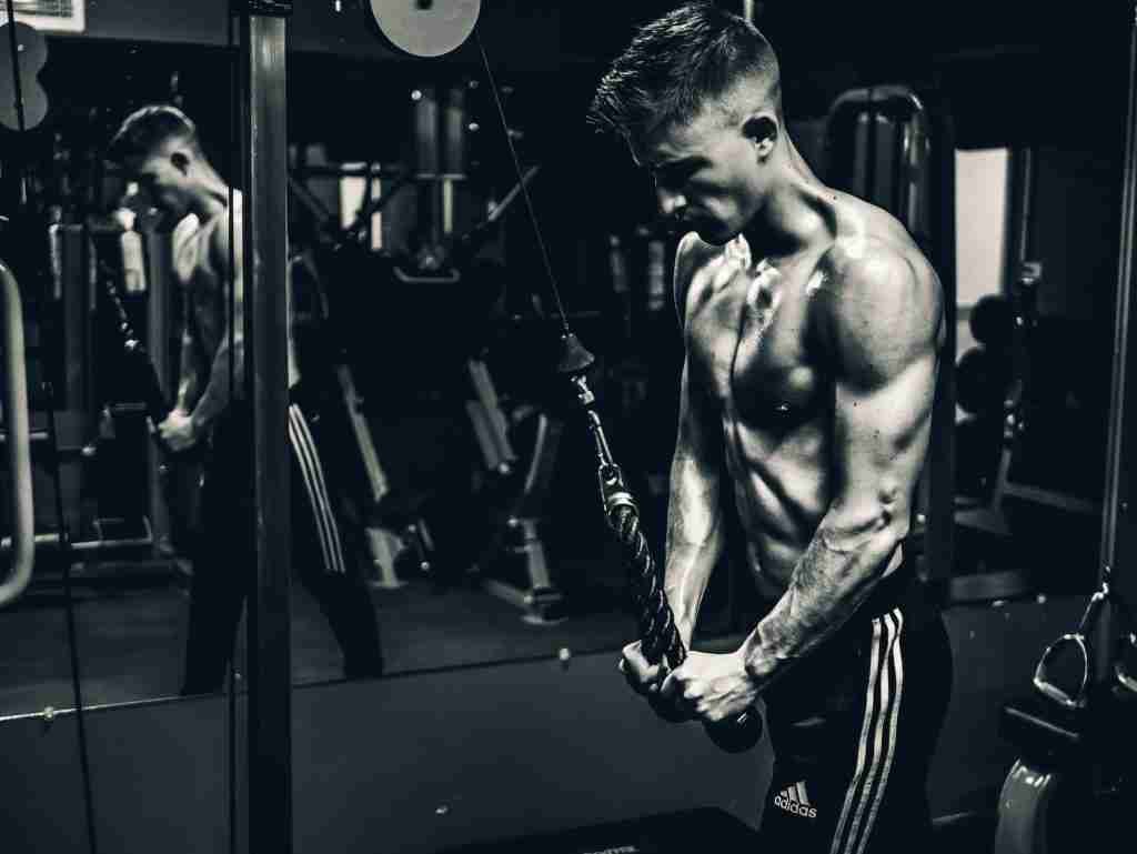 grayscale photo of man exercising (Tricep Pushdowns)