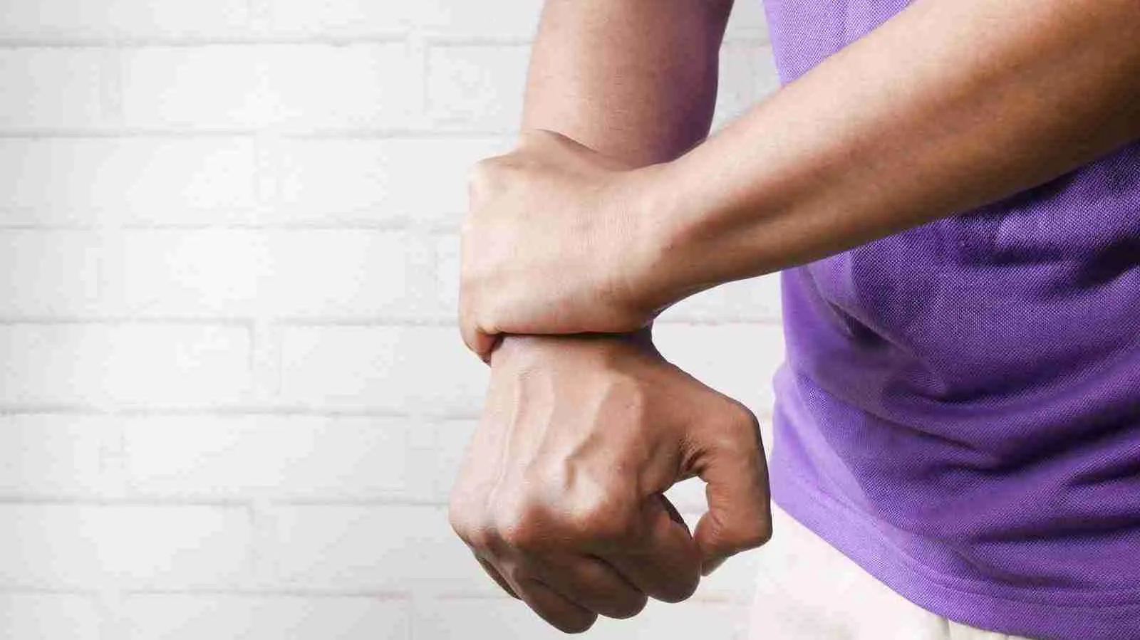 person holding his hand as a show of discomfort