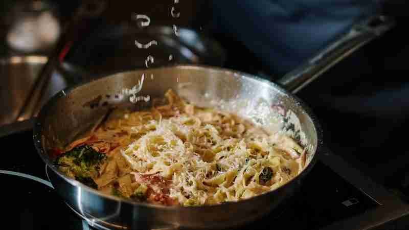Person Holding Stainless Steel Cooking Pot With Pasta