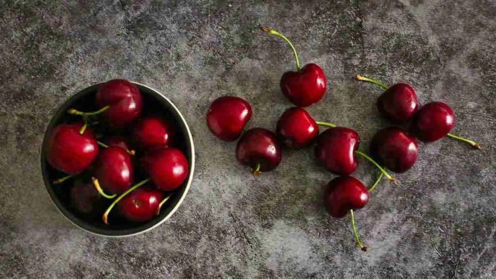 red cherries on black round plate