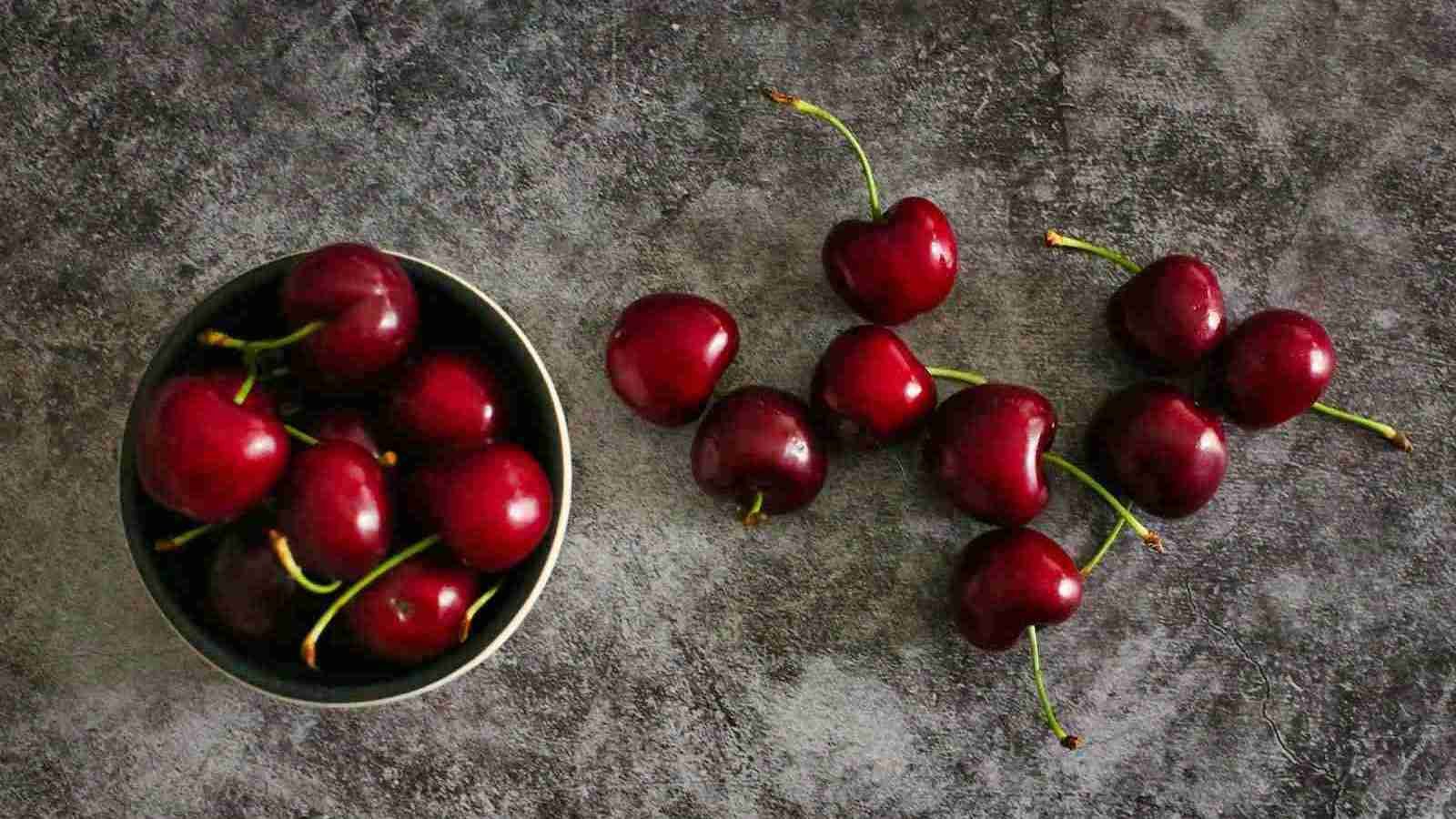 red cherries on black round plate