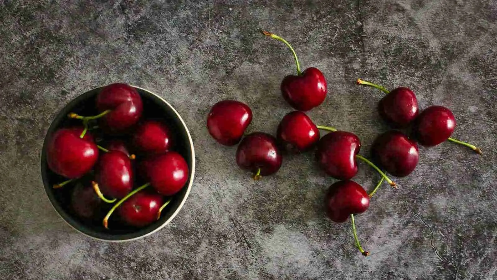 red cherries on black round plate