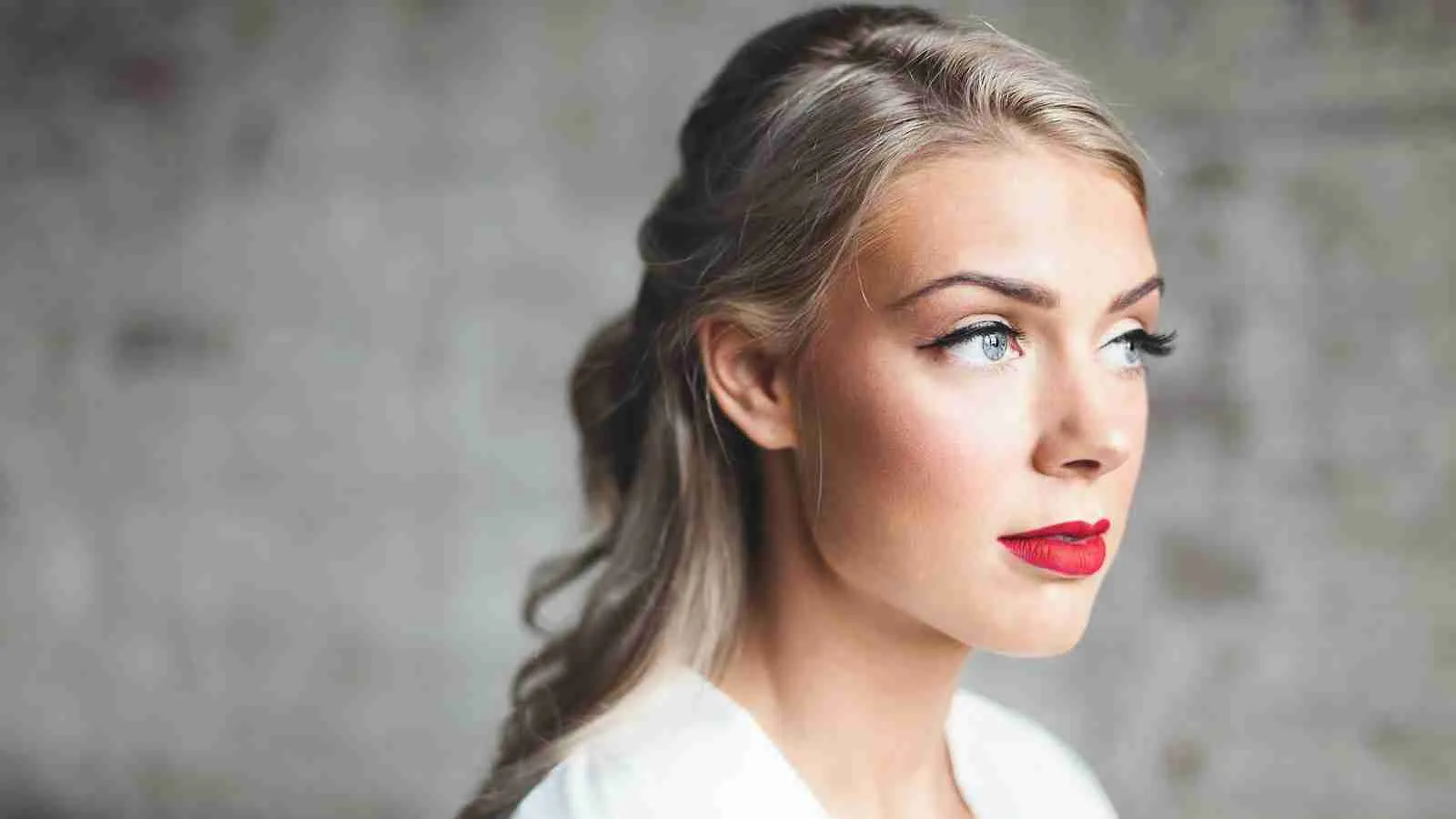 woman wearing white shirt with red lipstick having a glowing skin