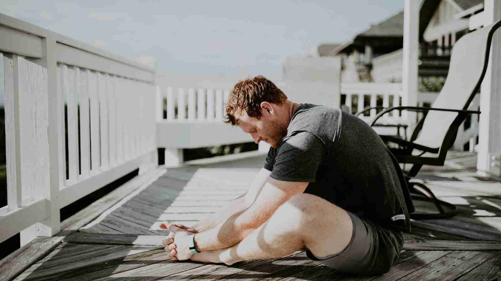 man doing yoga in porch