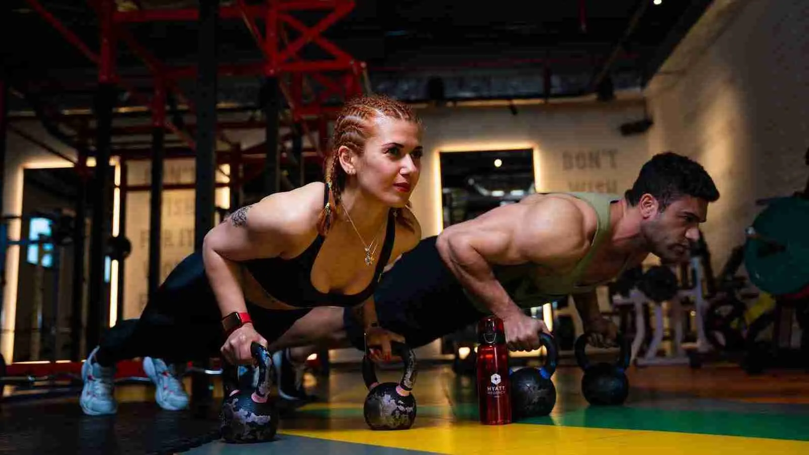 a man and a woman doing push ups with dumbbells