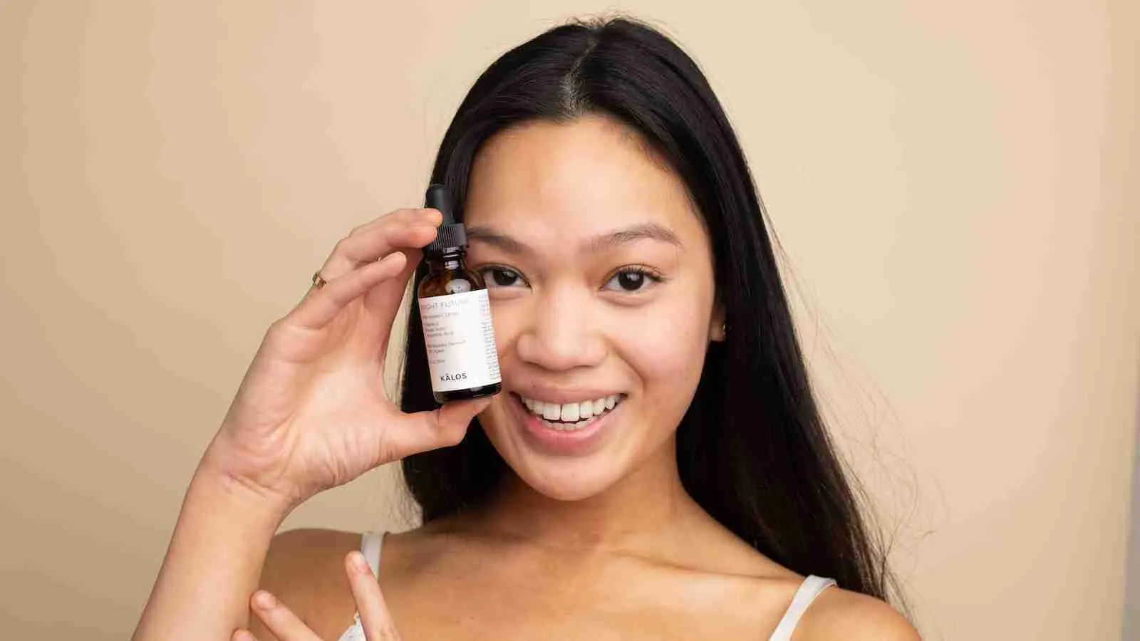 woman in white tank top holding white labeled bottle