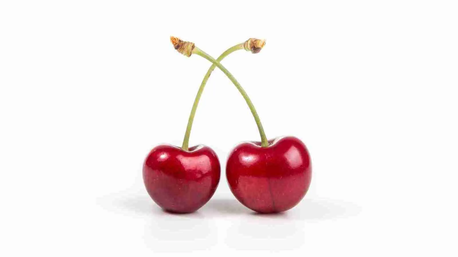 two cherries on white surface