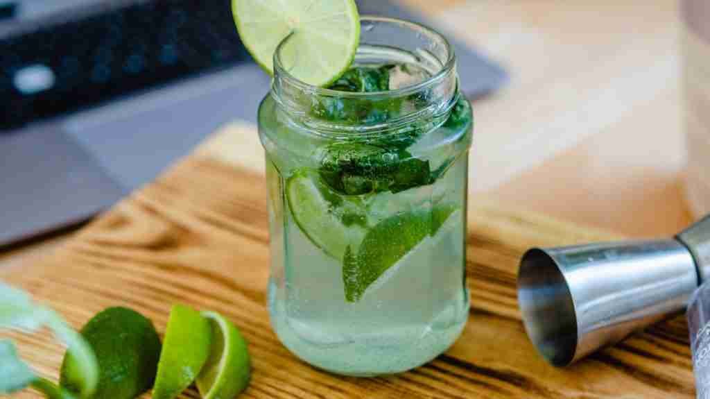 clear glass cup with green liquid and sliced lemon