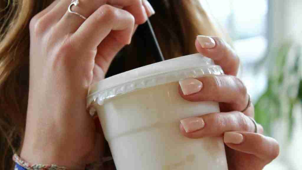 person holding white plastic cup