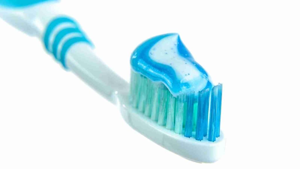 Blue and White Toothpaste on Toothbrush