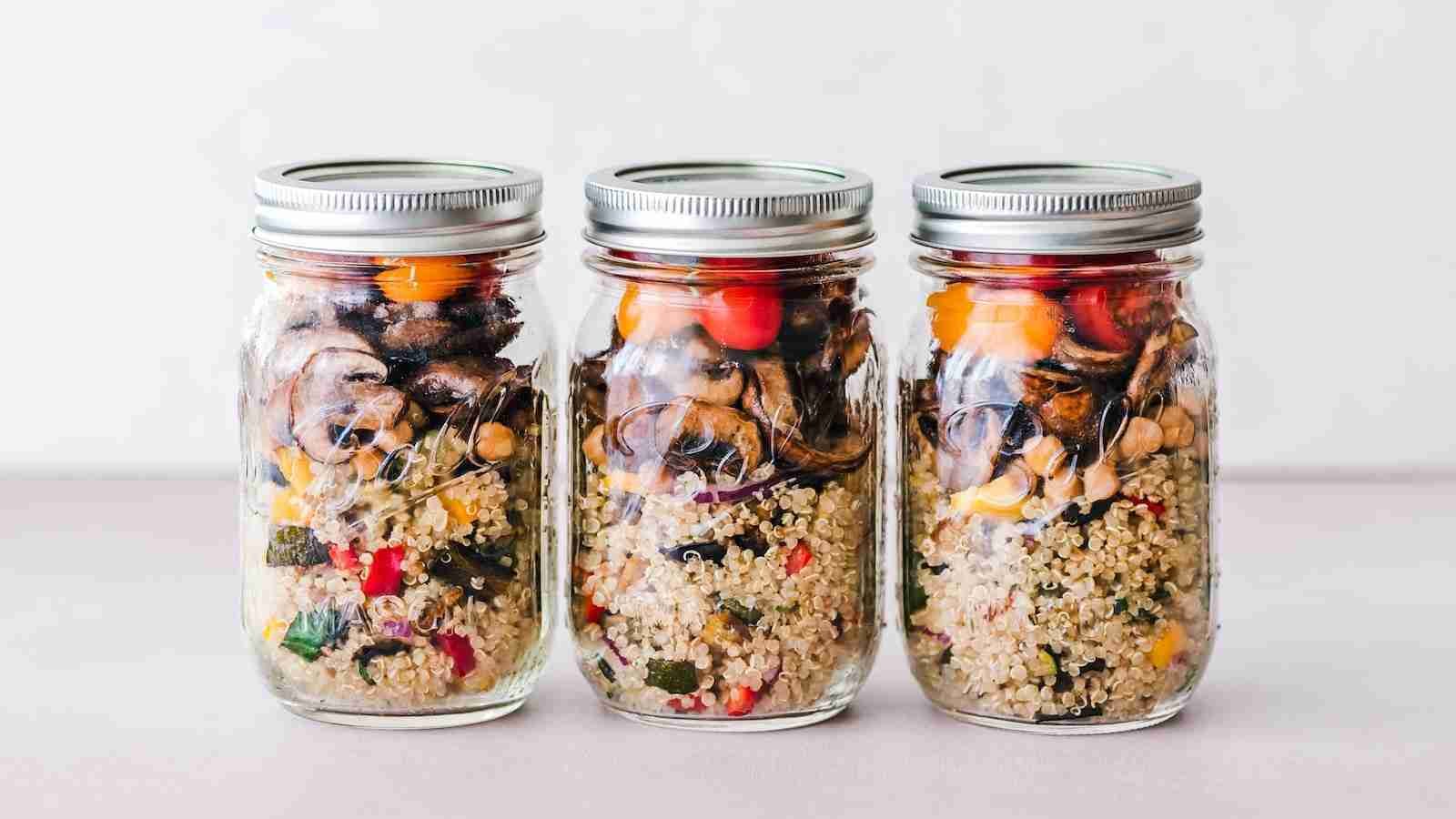 three full clear glass jars with with quinoa inside as well and other whole grains