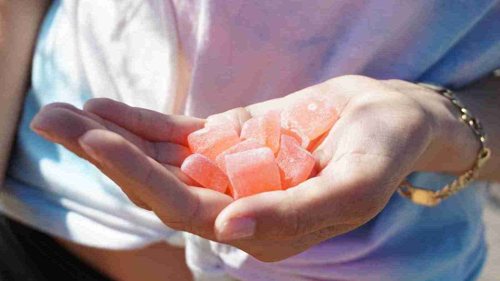 person holding orange gummies in his hand