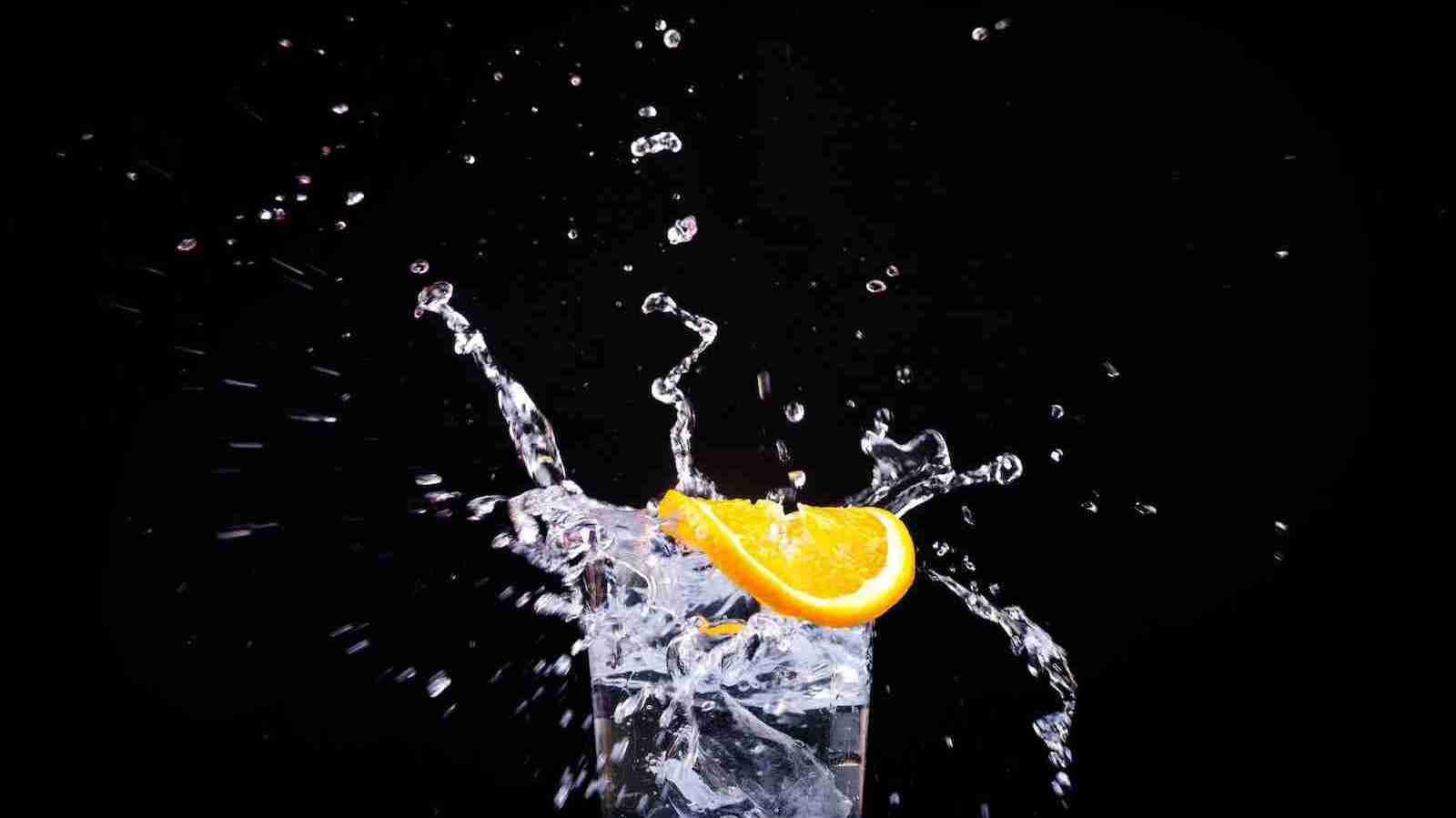 splash of water in drinking glass with sliced lemon