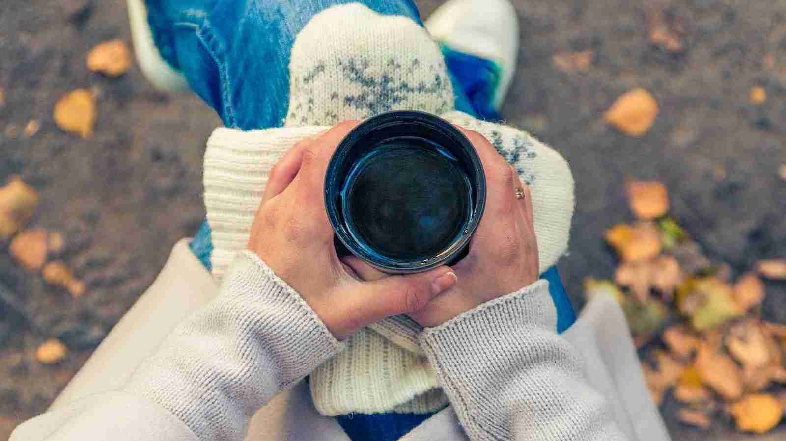 person holding black cup on her lap