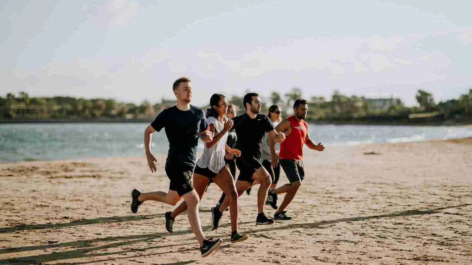 men and women running on sea shore