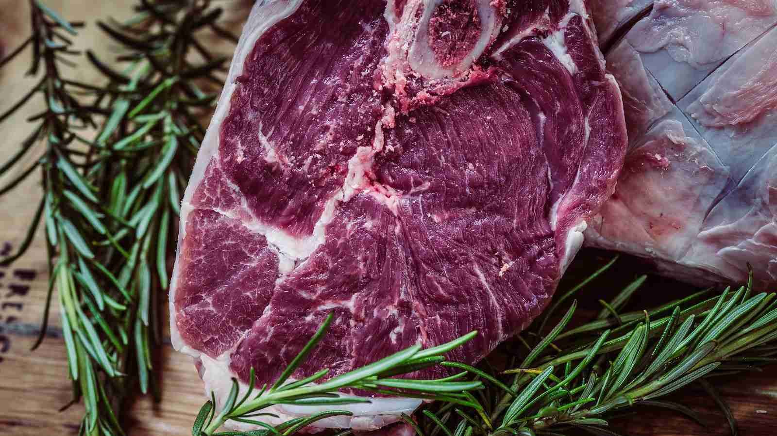 raw meat and green leaf plant on brown surface