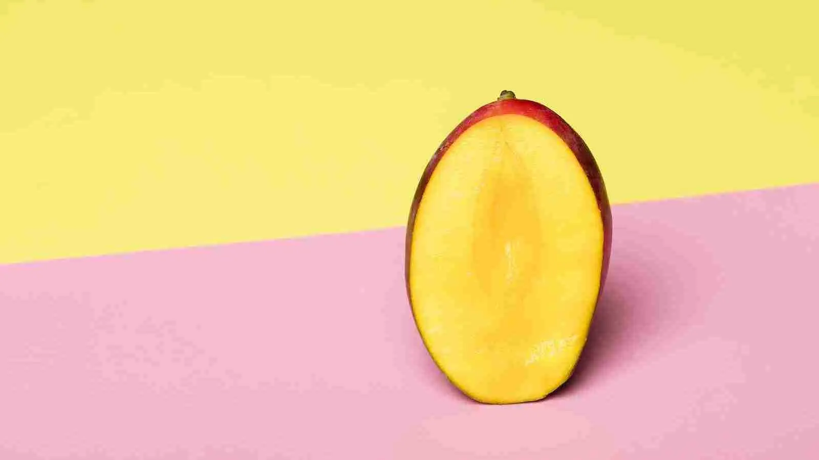 sliced mango on pink surface
