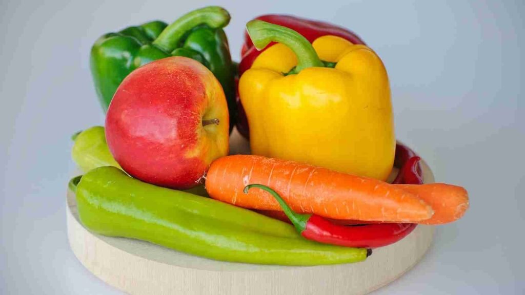 red and green bell pepper and red apple on white plate