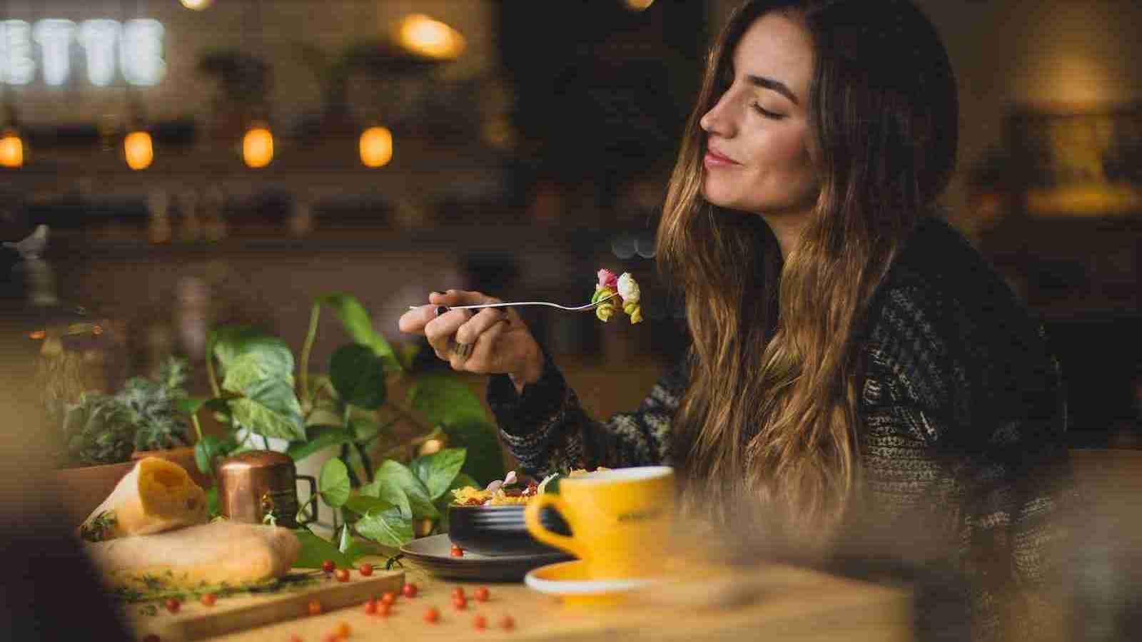 woman holding fork in front table