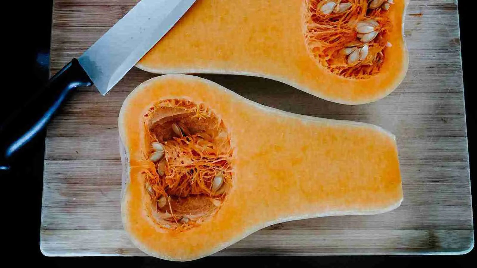stainless steel knife on brown wooden chopping board with Butternut Squash