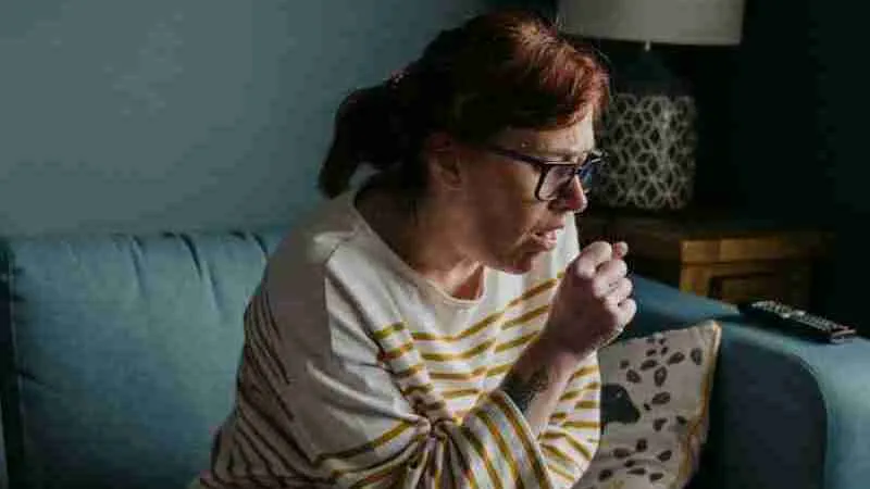 woman in white crew neck t-shirt sitting on gray sofa