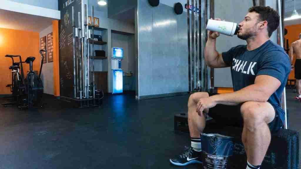 person in a gym drinking protein shake