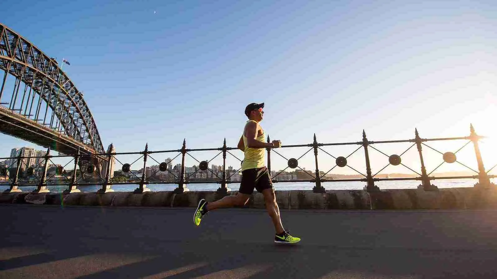 man in tank top running near shore