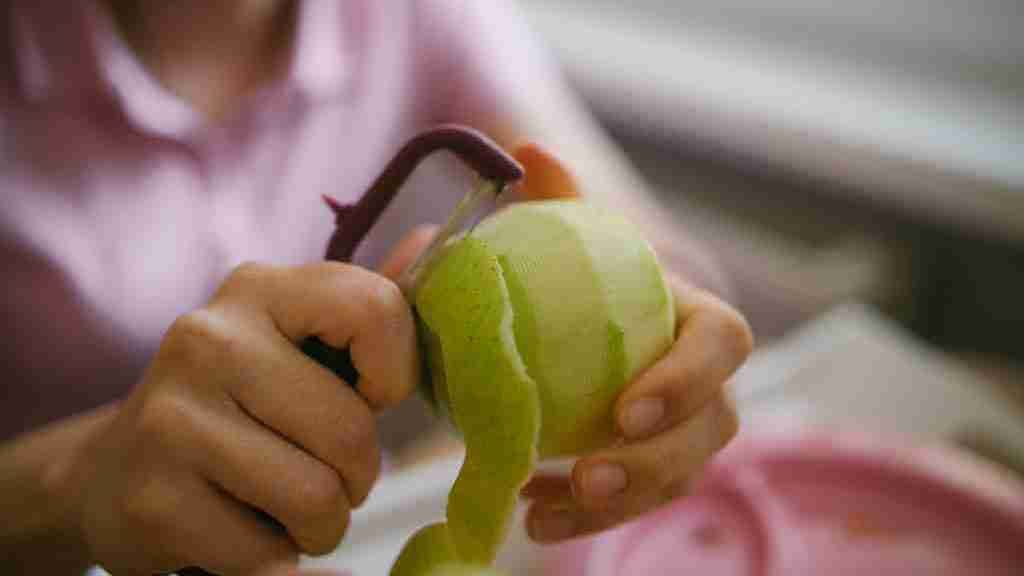 A person peeling an apple