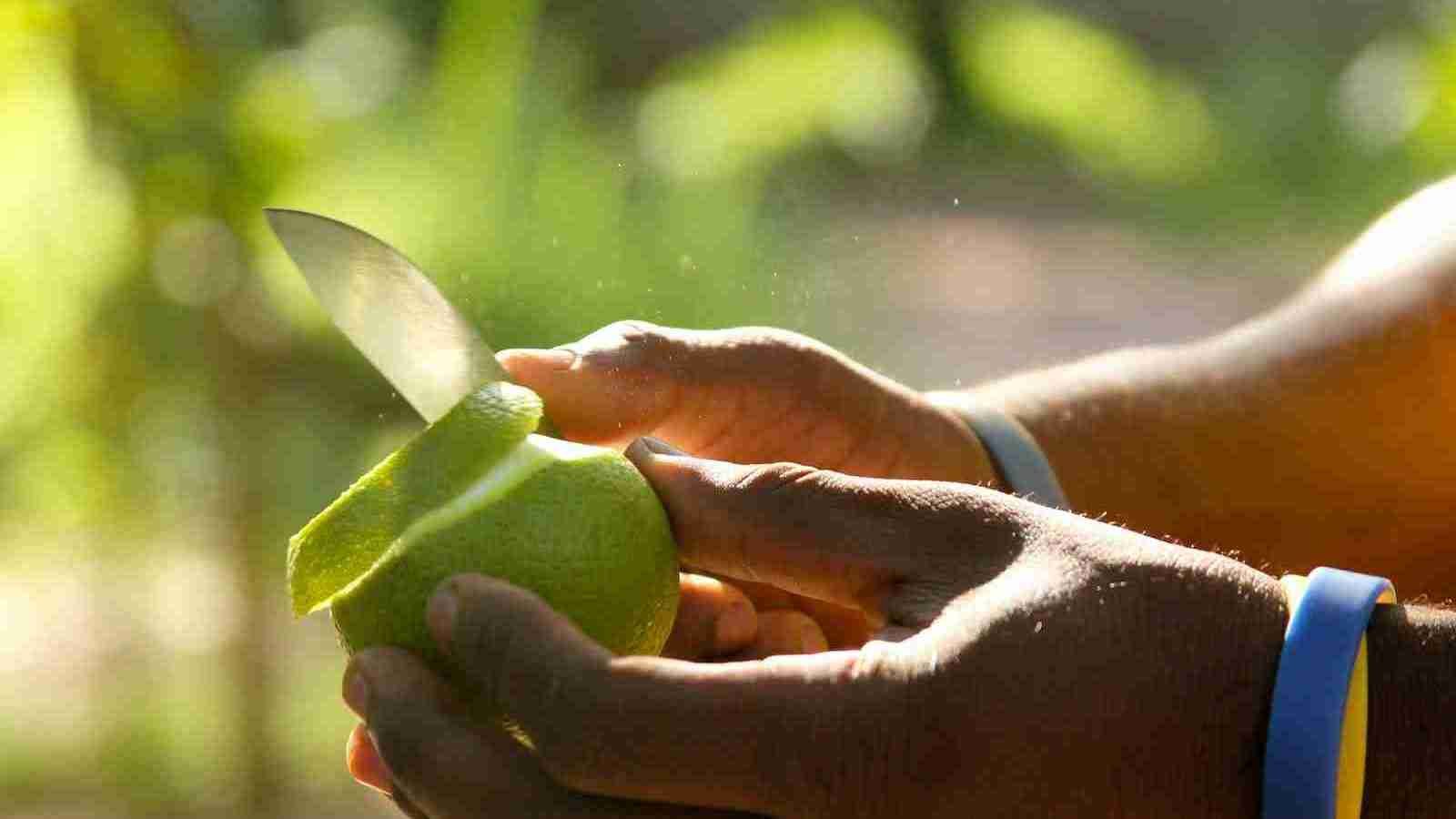 person peeling a green apple