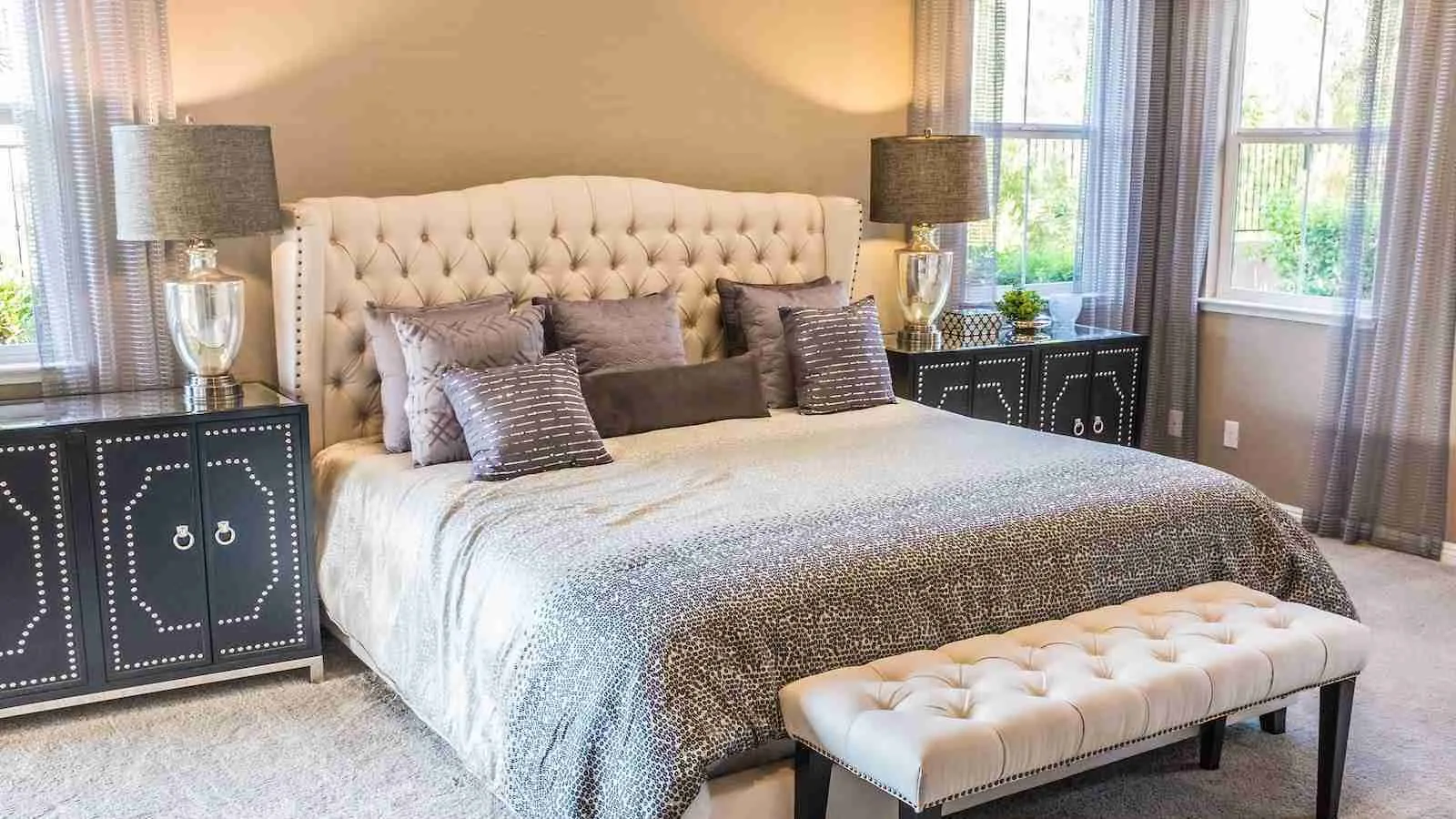 throw pillow on bed frame with lamps and sunlight coming from windows