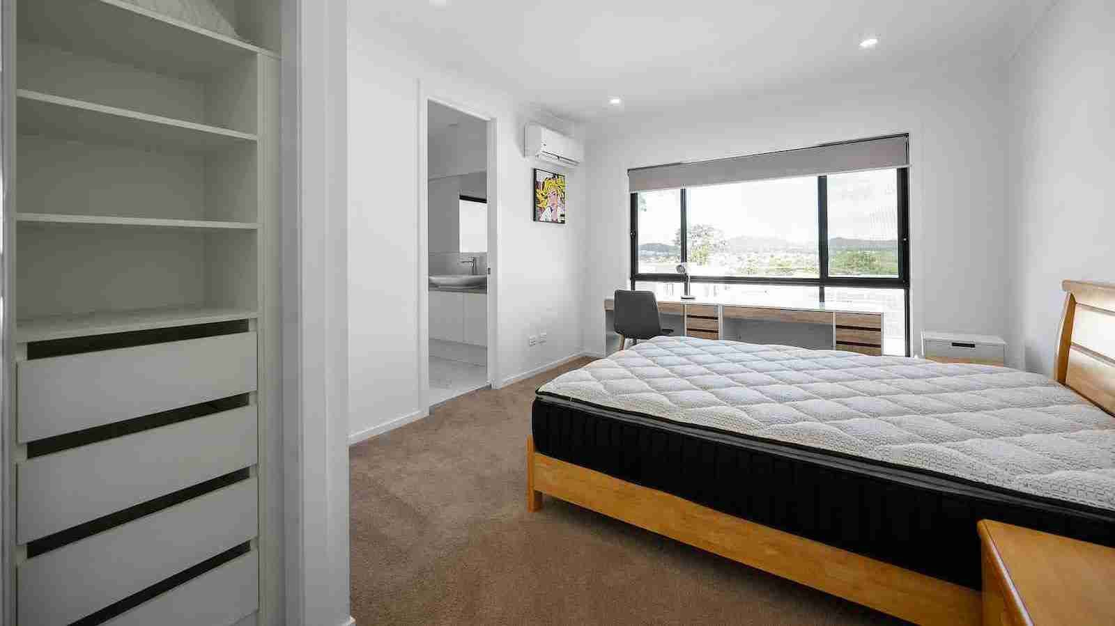 A bedroom with a mattress laid bare on a bed