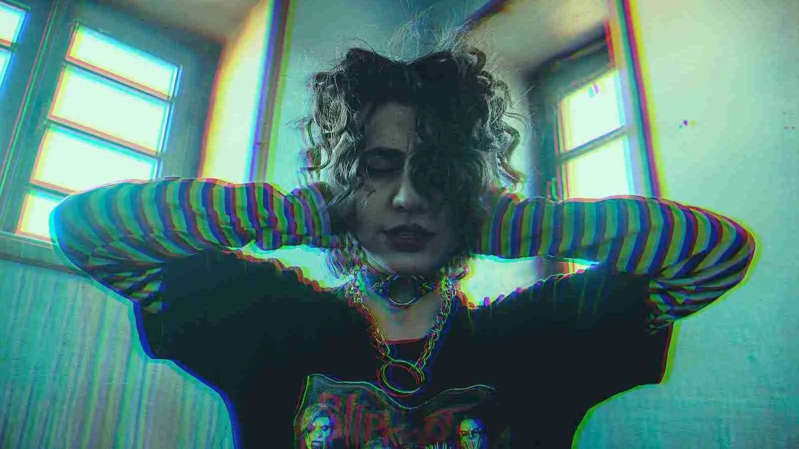 woman in blue and black striped long sleeve shirt covering her ears