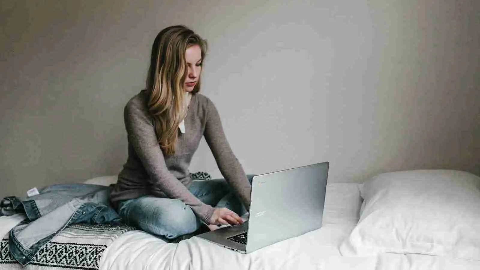 woman typing on MacBook Pro while sitting on bed in room which is wrong